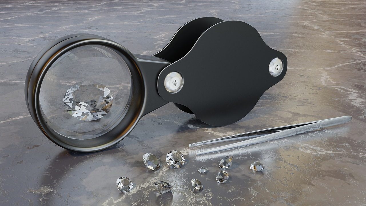 Bague tenue à la pince par un bijoutier, loupe en arrière-plan
