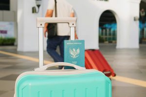 Valise cabine rigide avec roulettes posée devant un comptoir d'embarquement d'aéroport