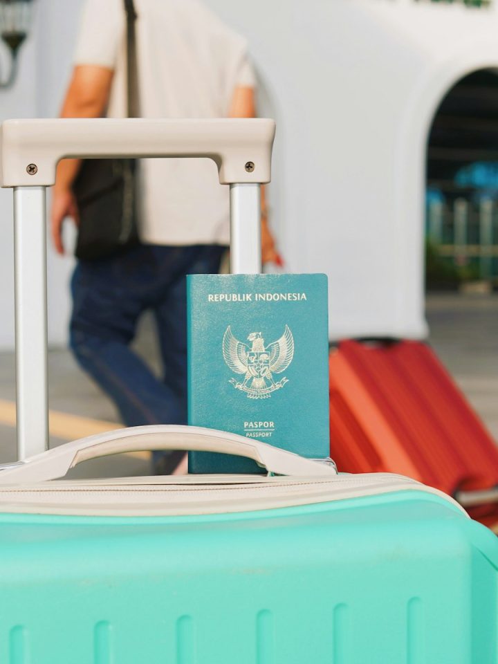 Valise cabine rigide avec roulettes posée devant un comptoir d'embarquement d'aéroport