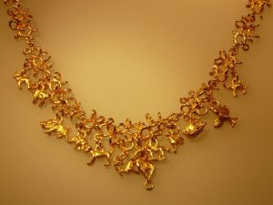 Femme portant plusieurs colliers en or superposés de longueurs différentes