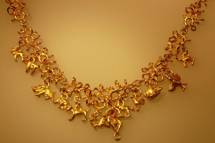 Femme portant plusieurs colliers en or superposés de longueurs différentes