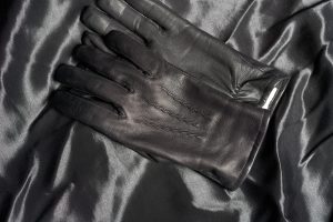 Paire de gants en cuir marron posés pliés l'un sur l'autre sur un fond neutre