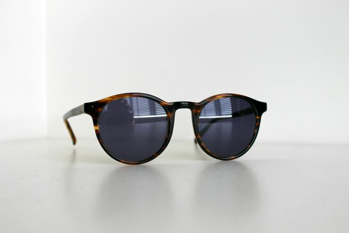 Paire de lunettes de soleil de catégorie 3 posée sur une table en bois
