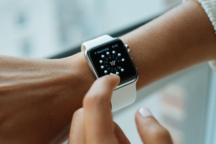 Montre connectée au poignet d'une femme, écran allumé affichant la fréquence cardiaque