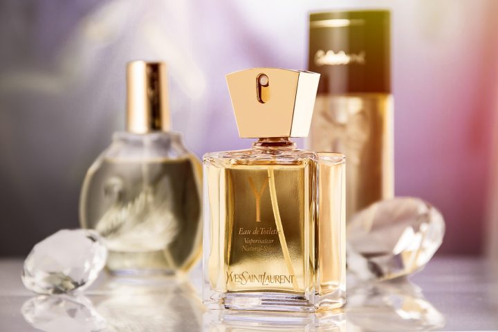 Flacon de parfum femme élégant posé à côté de fleurs fraîches