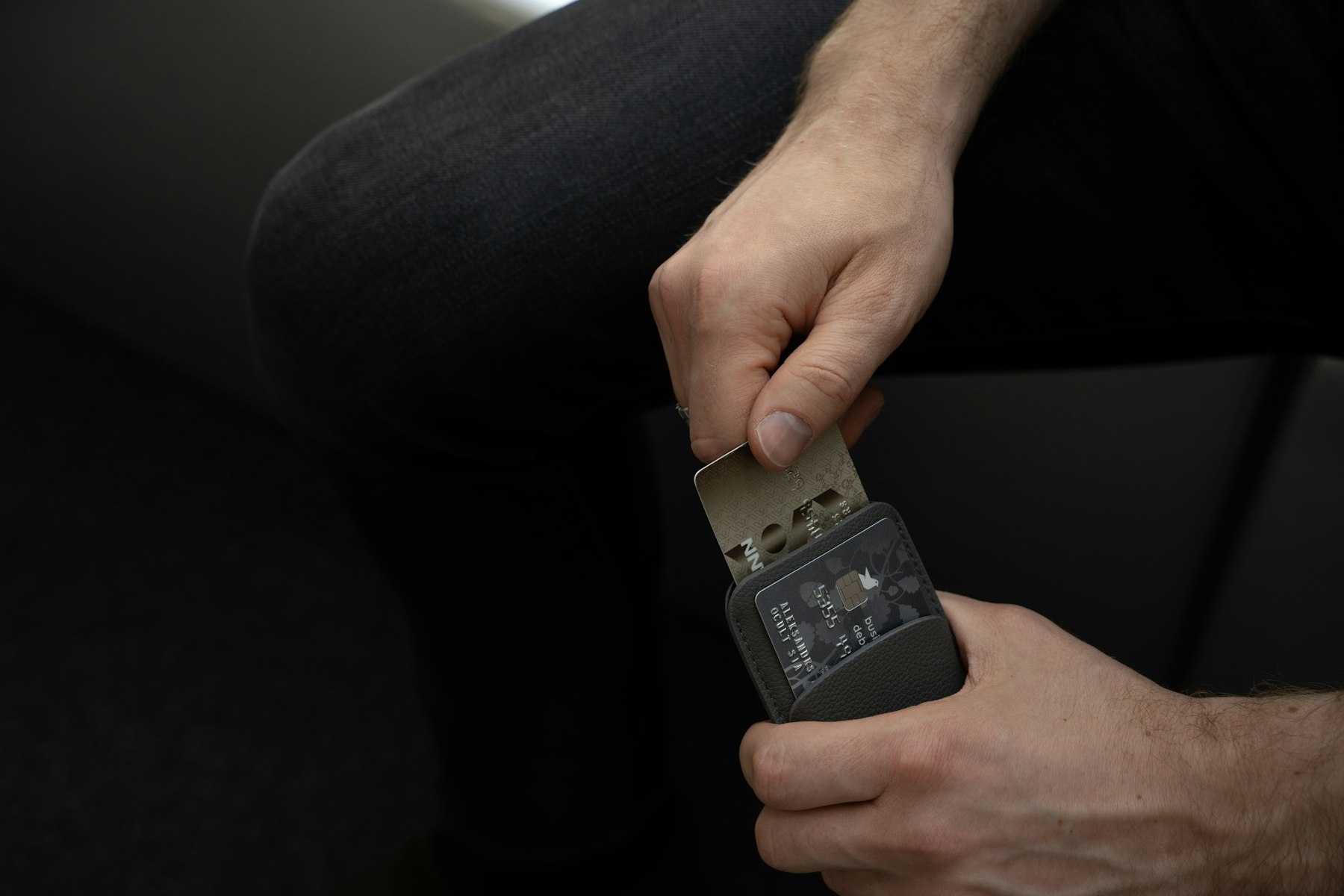 Porte-cartes en cuir fin glissé dans la poche avant d'un jean