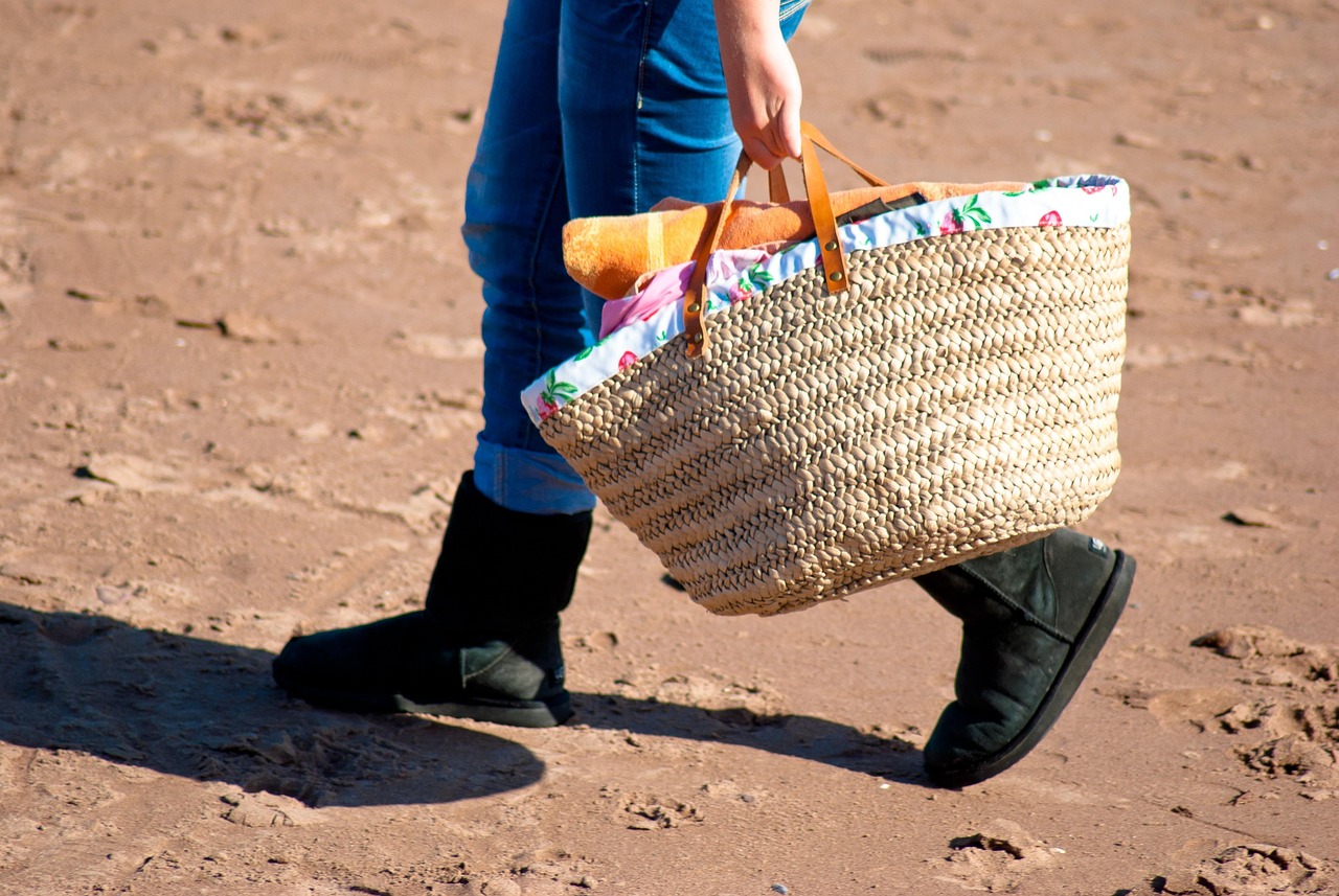 Tote bag en toile de coton et cuir porté à la main, poches visibles