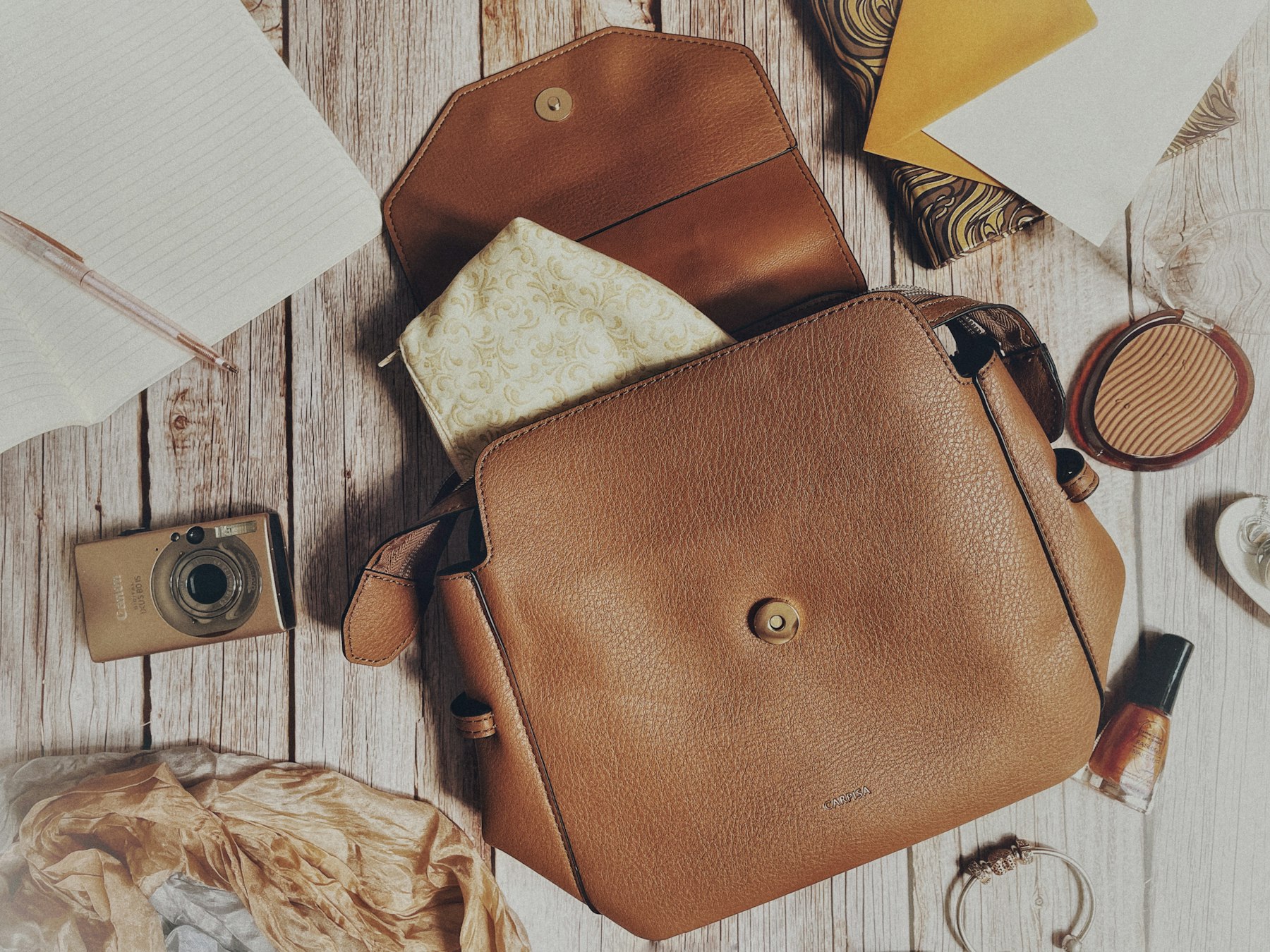 Sac à main, ceinture en cuir, montre et bijoux disposés ensemble, assortis dans une même palette de couleurs